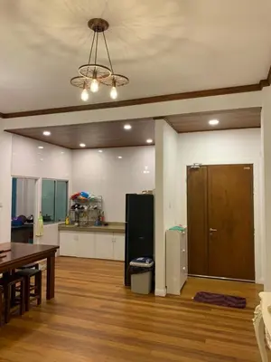 a living room with a table and a refrigerator at HappyHomestay in Brinchang