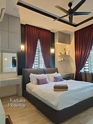a bedroom with a large bed with a ceiling fan at Modern Classy Karliana Homestay Penang in Kepala Batas