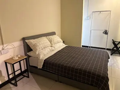 a bedroom with a bed with a black and white blanket at Nibong Tebal Studio Home Stay in Nibung Tebal
