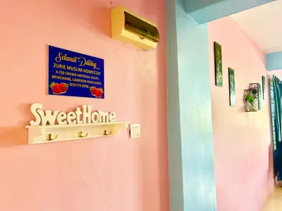 a hallway with a pink wall with a sign on it at Zurie Muslim Homestay in Brinchang