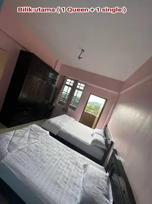 a bedroom with two beds and a window at Zurie Muslim Homestay in Brinchang