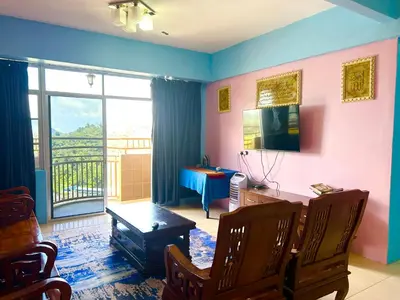 a living room with a desk and a balcony at Zurie Muslim Homestay in Brinchang