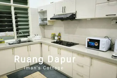 a white kitchen with a sink and a microwave at Iman Cottage Homestay Hospital Kulim Hitech in Kulim
