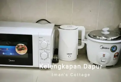 a microwave sitting next to a blender and a toaster at Iman Cottage Homestay Hospital Kulim Hitech in Kulim