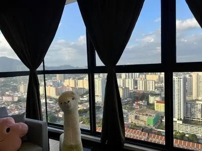 two stuffed animals sitting in a window with a view at Urban Suites R l 6pax 2R2B l SeaView &CityView l Georgetown in Jelutong