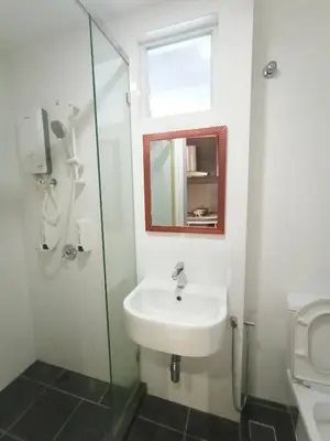 a bathroom with a sink and a mirror and a toilet at Maritime Suite @ George town by Cohans in Jelutong