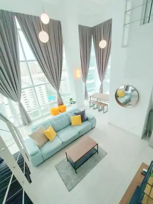 a living room with a blue couch and a table at Maritime Suite @ George town by Cohans in Jelutong