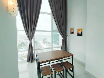 a table and chairs in front of a large window at Maritime Suite @ George town by Cohans in Jelutong