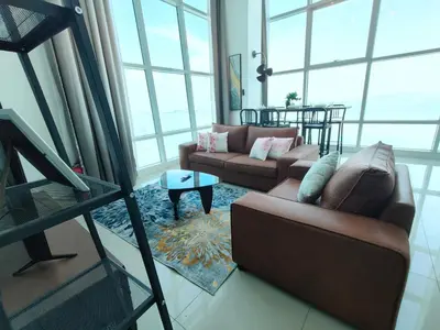 a living room with two couches and a table at Maritime Suite @ George town by Cohans in Jelutong