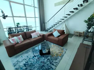 a living room with two couches and a table at Maritime Suite @ George town by Cohans in Jelutong