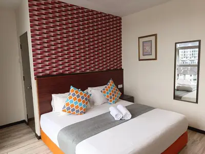 a bedroom with a bed with two towels on it at Beautiful Marigold Hotel in Tanah Rata