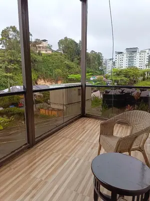 a balcony with a table and chairs and windows at Beautiful Marigold Hotel in Tanah Rata