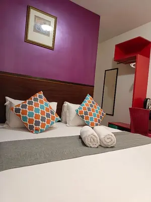 a hotel room with a bed with towels on it at Beautiful Marigold Hotel in Tanah Rata