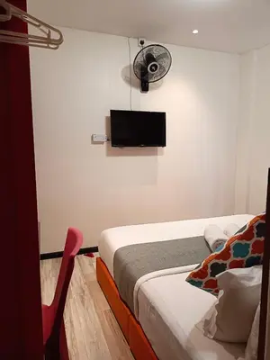 a bedroom with a bed and a flat screen tv on the wall at Beautiful Marigold Hotel in Tanah Rata