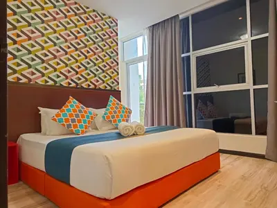 a bedroom with a large bed and a large window at Beautiful Marigold Hotel in Tanah Rata