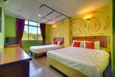 a hotel room with two beds and a television at DJ Seafront Hotel in Lumut