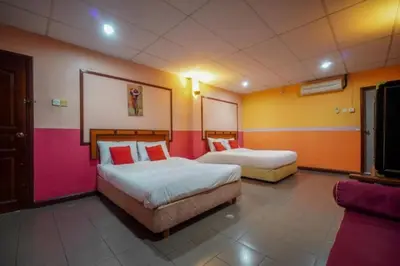 a hotel room with two beds and a tv at DJ Seafront Hotel in Lumut