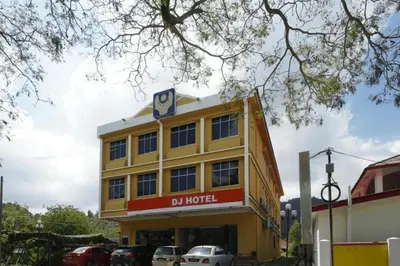 a yellow building with a sign on top of it at DJ Seafront Hotel in Lumut