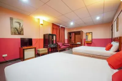 a hotel room with two beds and a tv at DJ Seafront Hotel in Lumut