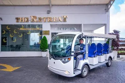a man riding a golf cart in front of a store at Nova Highlands Hotel in Cameron Highlands