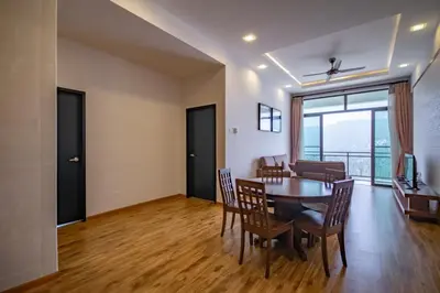 a dining room and living room with a table and chairs at Nova Highlands Hotel in Cameron Highlands