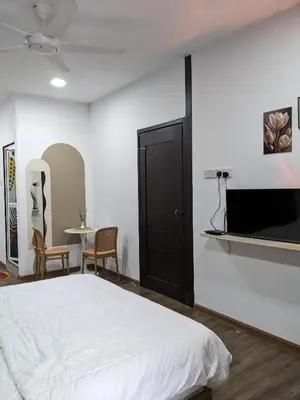 a bedroom with a bed and a tv and a table at Rods Homestay - Kg Agong Penaga in Kepala Batas