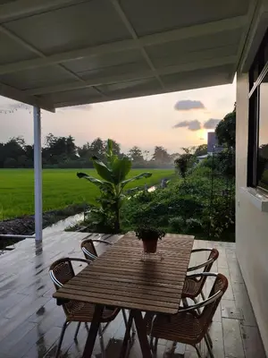 a wooden table and chairs on a patio at Mai Paddy Cottage, Balik Pulau in Balik Pulau