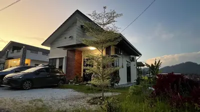 a house with a car parked in front of it at Mai Paddy Cottage, Balik Pulau in Balik Pulau