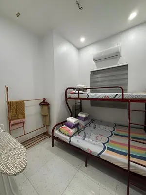 a small room with two bunk beds and a chair at Aufa House in Padang Rengas