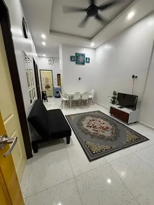 a living room with a black chair and a rug at Aufa House in Padang Rengas