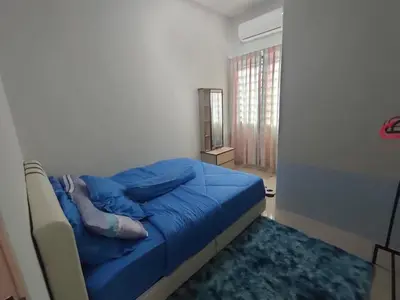 a woman laying on a bed in a bedroom at Homestay Gerik Le rizq Homestay~ Heart of Gerik ~ Cozy in Gerik
