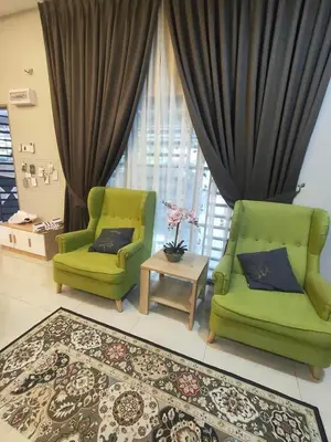 a living room with two green chairs and a table at Homestay Gerik Le rizq Homestay~ Heart of Gerik ~ Cozy in Gerik