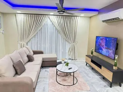a living room with a couch and a flat screen tv at YK Sweet home sungai petani 1 @ 16 people above in Sungai Petani