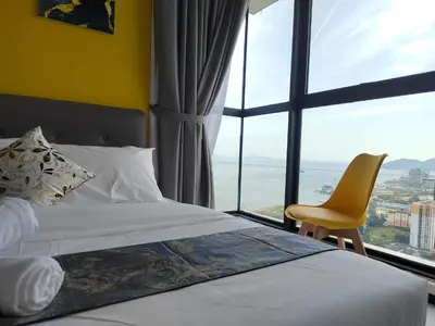 a bedroom with a bed and a chair and a large window at Seaview Infinity Pool , 40th , 9pax, 3Rooms 2Carpark in Jelutong