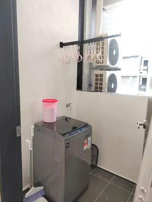 a kitchen with a washing machine with a pink bucket on it at Seaview Infinity Pool , 40th , 9pax, 3Rooms 2Carpark in Jelutong