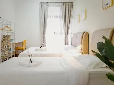 a bedroom with two beds and a window and a table at Ipoh Cove Hillview Suite 7-8 pax Tambun Lost World by City Home Empire in Ipoh