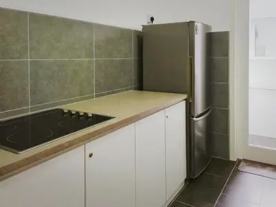 a kitchen with white cabinets and a stainless steel refrigerator at Ipoh Cove Hillview Suite 7-8 pax Tambun Lost World by City Home Empire in Ipoh