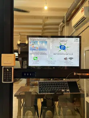 a computer monitor and a keyboard on a glass table at Dou Houz Georgetown in George Town