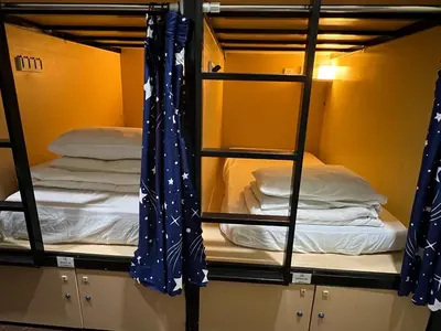 a room with bunk beds with blue curtains at Dou Houz Georgetown in George Town