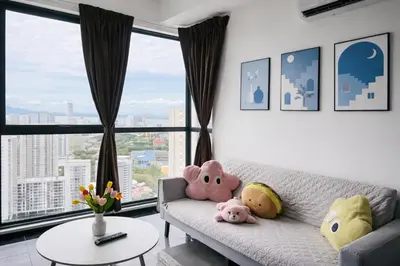 a living room with a couch with stuffed animals on it at Urban Suites Georgetown l SeaView & CityView l Family Stay in Jelutong