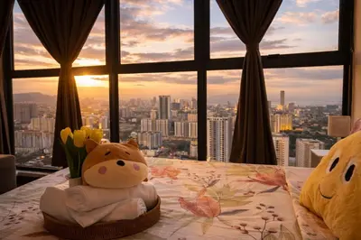 a table with a vase of flowers and a window at Urban Suites Georgetown l SeaView & CityView l Family Stay in Jelutong
