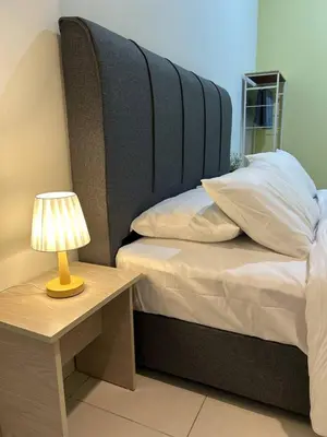 a bedroom with a bed with a lamp on a table at Havengate Homestay in Butterworth