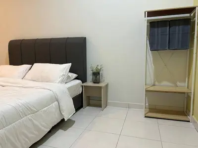 a bedroom with a bed with a black headboard at Havengate Homestay in Butterworth