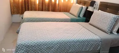 two beds sitting next to each other in a room at Hotel Blue Orchid in Bayan Lepas