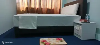 a bedroom with a bed and a small table with a bed gmaxwell gmaxwell at Hotel Blue Orchid in Bayan Lepas