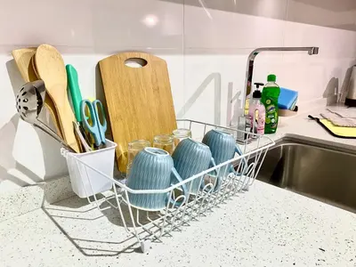 a dish drying rack next to a sink with utensils at Decozy 8.0 IpohTownCondo (10pax) in Ipoh