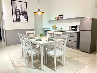a kitchen with a table and chairs and a refrigerator at Decozy 8.0 IpohTownCondo (10pax) in Ipoh