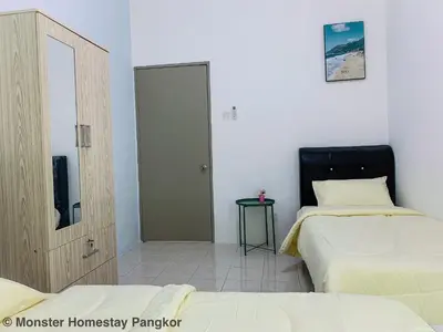 a bedroom with two beds and a mirror and a door at Sunshine Lot 10 Pangkor in Kampong Sungai Udang