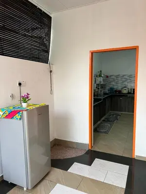 a room with a refrigerator and a kitchen at Agro Village Stay in Tapah