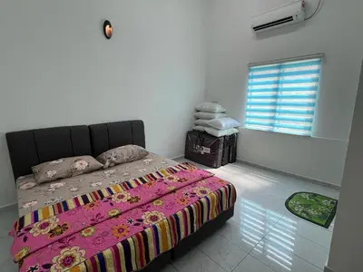 a bedroom with a bed with a pink blanket and a window at Agro Village Stay in Tapah